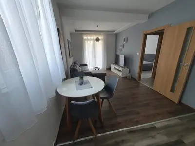 a living room with a white table and chairs at JOX Apartment in Podgorica
