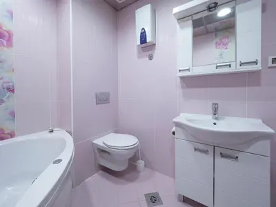 a white bathroom with a toilet and a sink at Skyline Penthouse Budva in Budva