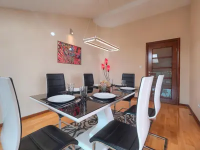 a dining room with a black table and chairs at Skyline Penthouse Budva in Budva