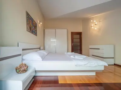 a bedroom with a large white bed in a room at Skyline Penthouse Budva in Budva