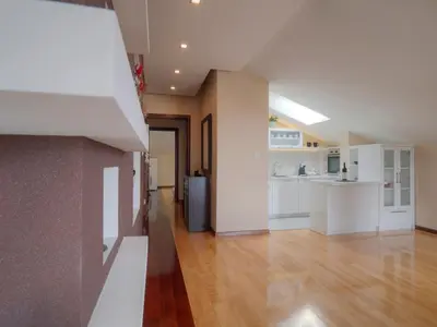 a kitchen with white cabinets and a hard wood floor at Skyline Penthouse Budva in Budva
