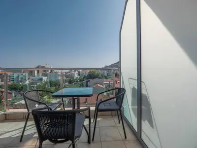 a table and chairs on a balcony with a view at Skyline Penthouse Budva in Budva