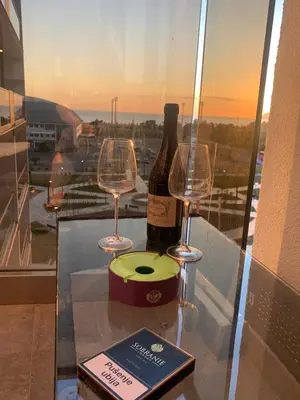 a bottle of wine and two wine glasses on a table at Bar Exclusiv Soho city Residence in Bar
