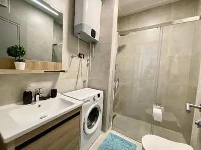 a bathroom with a sink and a washing machine at Casa Al Mare Residence Apartment Lena in Budva