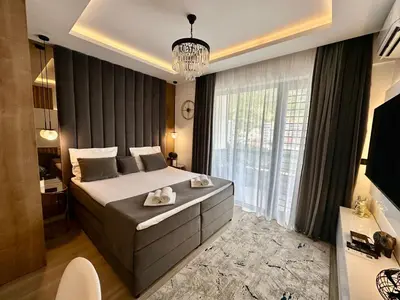 a bedroom with a large bed and a large window at Casa Al Mare Residence Apartment Lena in Budva
