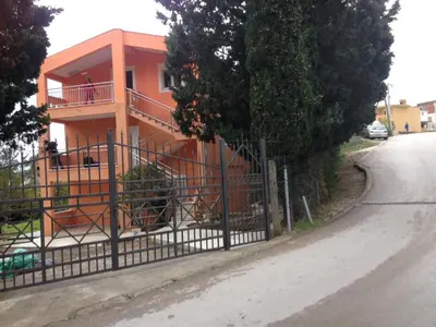 a house with an iron gate on the side of a street at Ruza vetrova in Bar