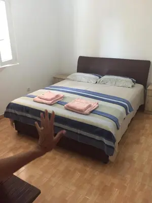 a bed with two folded towels on top of it at Ruza vetrova in Bar