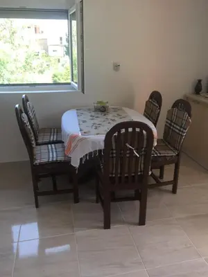 a dining room table with four chairs and a window at Ruza vetrova in Bar