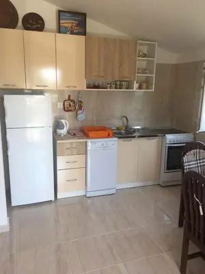 a kitchen with a white refrigerator and white appliances at Ruza vetrova in Bar
