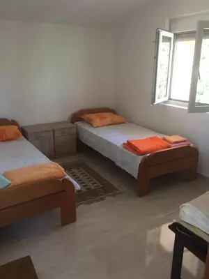 a bedroom with two twin beds and a window at Ruza vetrova in Bar