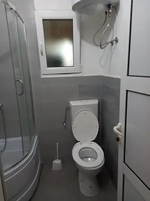 a small bathroom with a toilet and a window at MD Apartmani Canj in Čanj