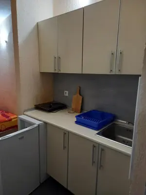 a kitchen with white cabinets and a blue container on the counter at MD Apartmani Canj in Čanj