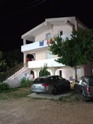 a car parked in front of a house at night at MD Apartmani Canj in Čanj