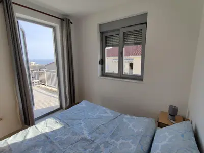 a bedroom with a bed and a window with a view at Good morning Petrovac in Petrovac na Moru