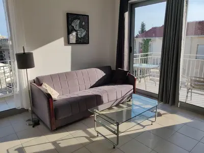 a living room with a couch and a glass table at Good morning Petrovac in Petrovac na Moru