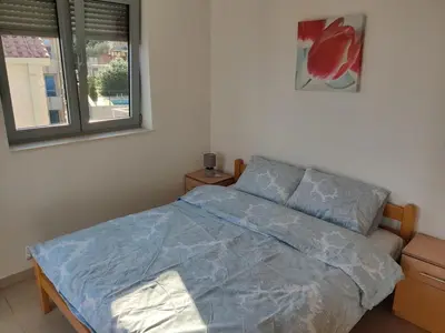 a bedroom with a bed with a blue comforter and a window at Good morning Petrovac in Petrovac na Moru