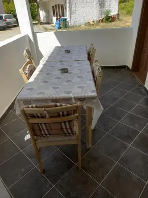 a table and chairs sitting on a porch with a table and a table and chairs at Vikendica in Čanj