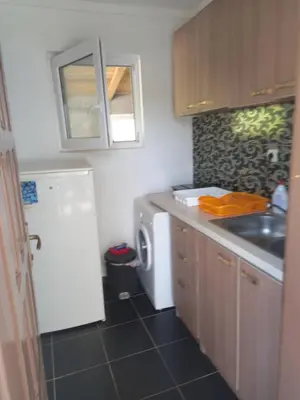 a kitchen with a white refrigerator and a washing machine at Vikendica in Čanj