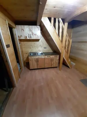 an attic room with a kitchen and wooden floors at Livari Rooms Exclusive Chalet in Bar