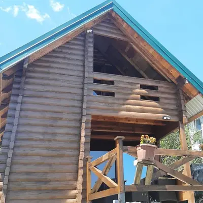 a wooden cabin with a flower pot on the porch at Livari Rooms Exclusive Chalet in Bar