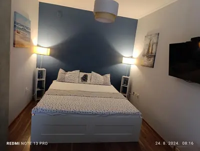 a bedroom with a bed with two lights on the wall at Apartment Anika in Becici