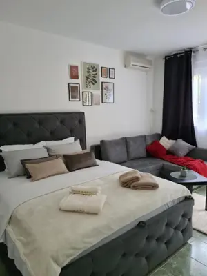 a bedroom with a large bed and a couch at Apartman Rosemary in Sveti Stefan
