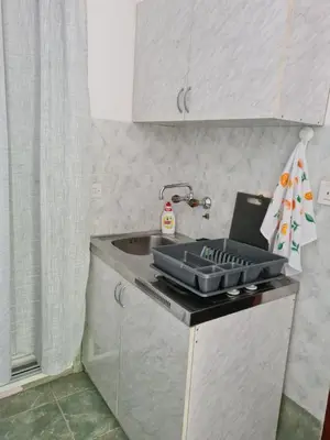 a kitchen with a sink with a tray on the counter at Apartman Rosemary in Sveti Stefan