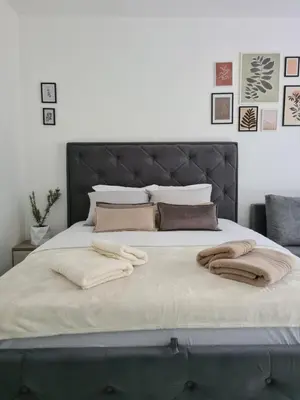 a bed with two blankets and pillows on it at Apartman Rosemary in Sveti Stefan