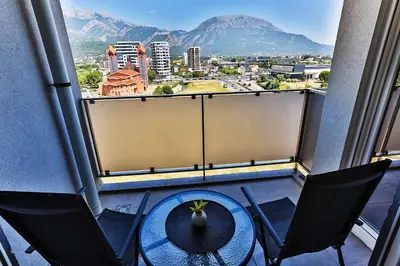 a balcony with a table and chairs and mountains at Apartment Alex in Bar