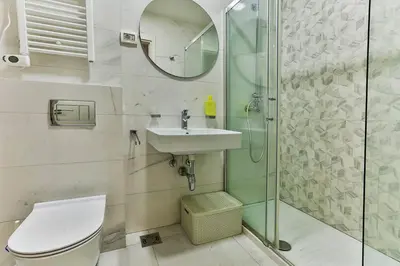 a bathroom with a toilet and a sink and a shower at Apartment Alex in Bar