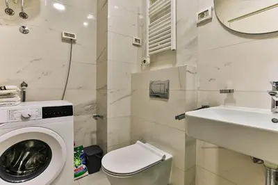 a bathroom with a washing machine and a sink at Apartment Alex in Bar
