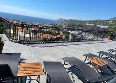 a patio with chairs and tables and the ocean at Villa Roki in Ravanj