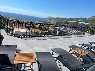 a patio with chairs and tables and a view of the ocean at Villa Roki in Ravanj