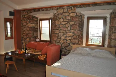 a bedroom with a bed and a stone wall at Etno house Velje Selo in Bar