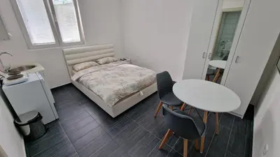 a bedroom with a bed and a table and chairs at Apartman Tolosi in Podgorica