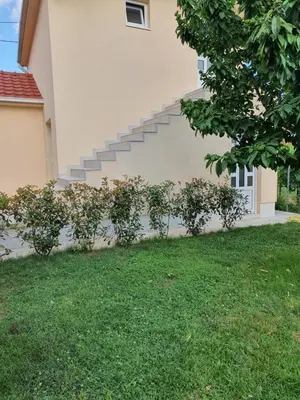 a house with stairs on the side of it at Apartman Tolosi in Podgorica