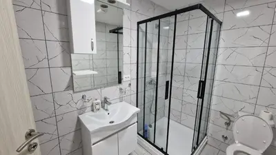 a bathroom with a shower and a toilet and a sink at Apartman Tolosi in Podgorica