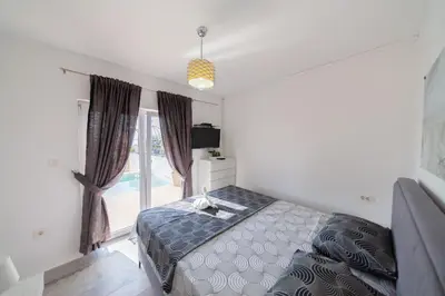 a bedroom with a bed and a large window at Villa Hacienda in Budva