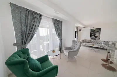 a living room with a green couch and chairs at Villa Hacienda in Budva