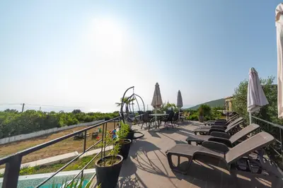 a row of chairs and umbrellas on a balcony at Villa Hacienda in Budva