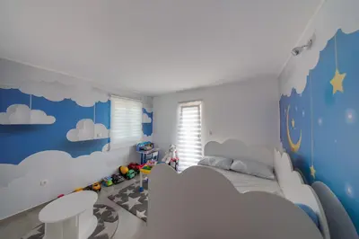 a childs bedroom with blue walls and clouds at Villa Hacienda in Budva