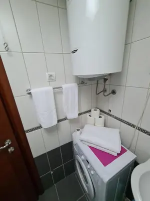 a bathroom with a washing machine and a sink at Seaview Apartment in Bar