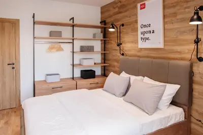 a bedroom with a bed with white sheets and pillows at Comfortable Apartment at CITY QUART in Podgorica