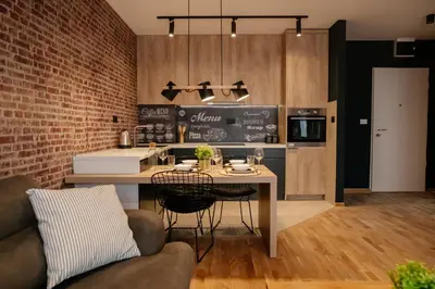 a kitchen with a table with chairs and a counter at Comfortable Apartment at CITY QUART in Podgorica