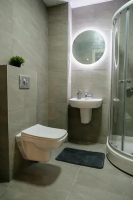 a bathroom with a toilet and a sink and a shower at Comfortable Apartment at CITY QUART in Podgorica