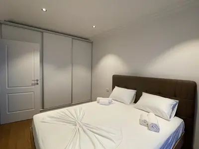 a bedroom with a bed with white sheets and white pillows at Lux Apartment Kamenovo in Sveti Stefan