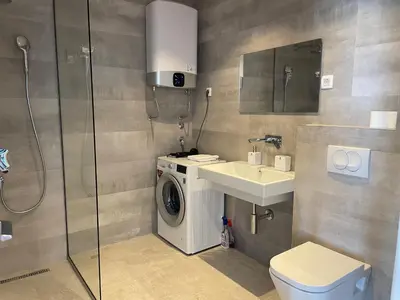 a bathroom with a washing machine and a sink at Lux Apartment Kamenovo in Sveti Stefan