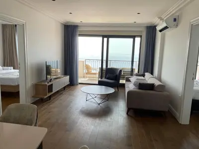 a living room with a couch and a bed and a television at Lux Apartment Kamenovo in Sveti Stefan
