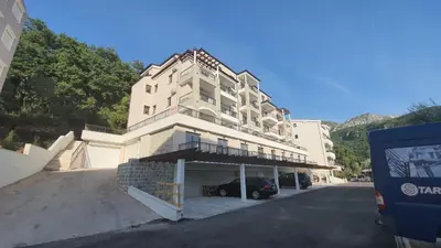 a building with a car parked in front of it at Lux Apartment Kamenovo in Sveti Stefan