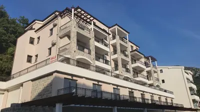 a white building with balconies on the side of it at Lux Apartment Kamenovo in Sveti Stefan
